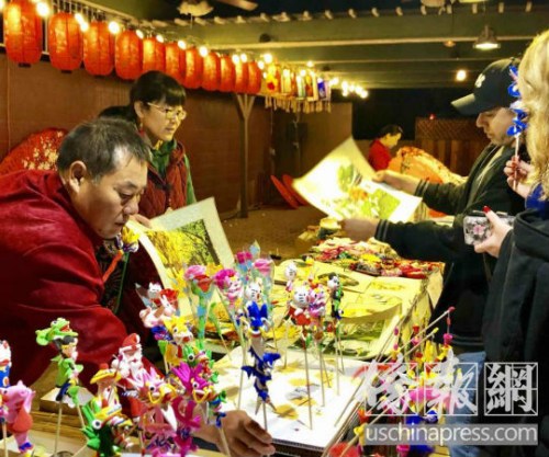 游客对中国传统艺术刺绣和泥塑人偶充满兴趣。(美国《侨报》/翁羽 摄) 